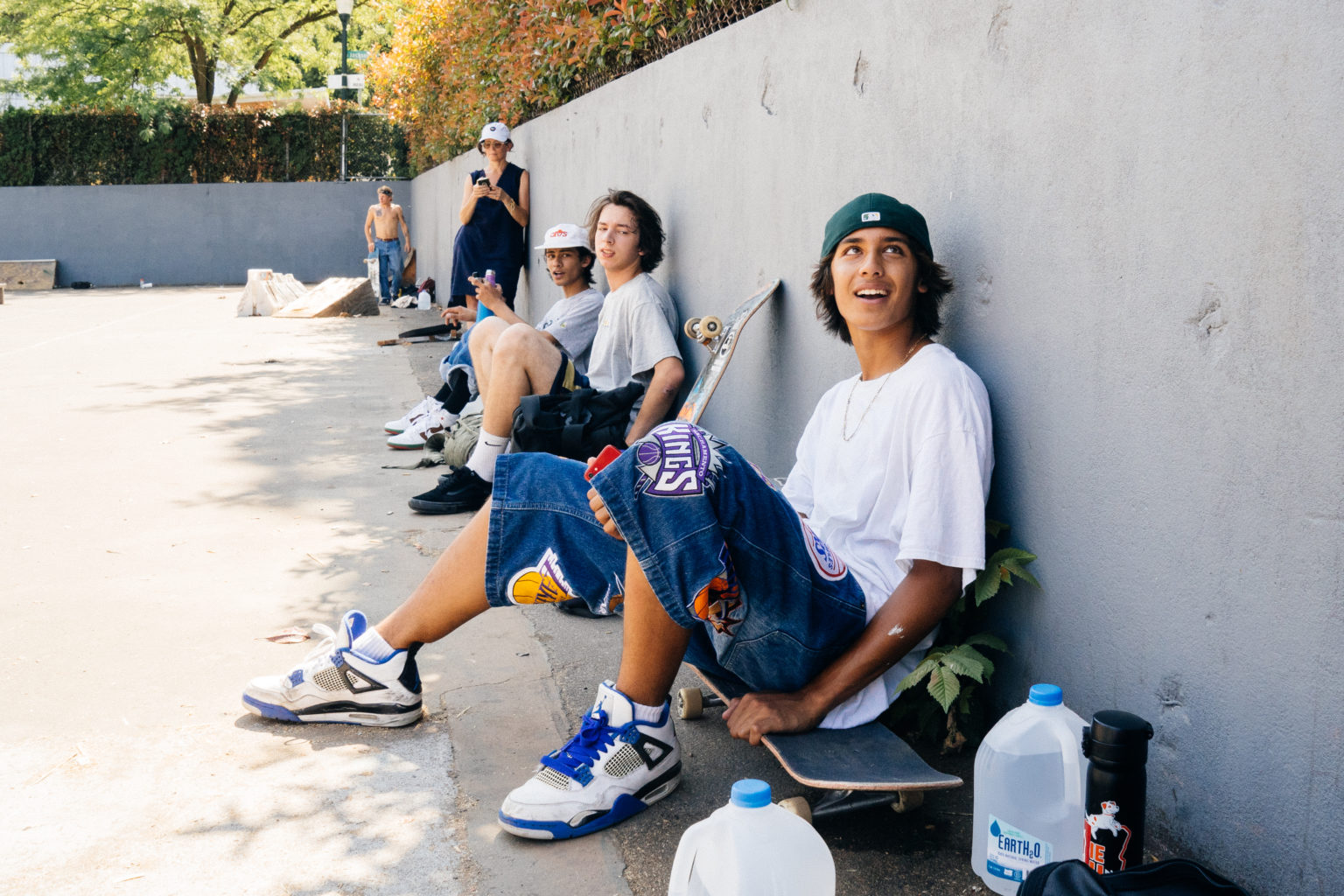 Skaters sitting against a wall outside