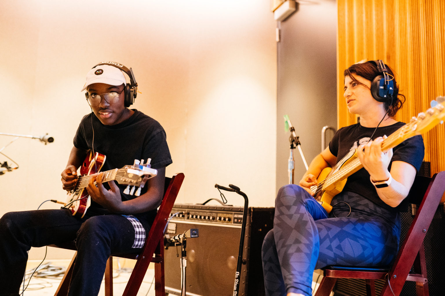 Students sitting and playing guitars in the studio