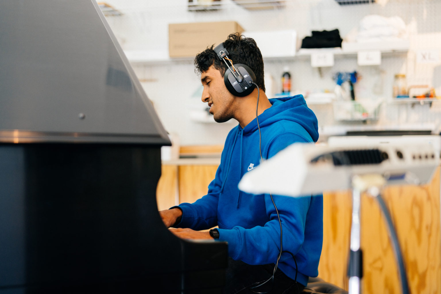 Student with headphones playing the piano