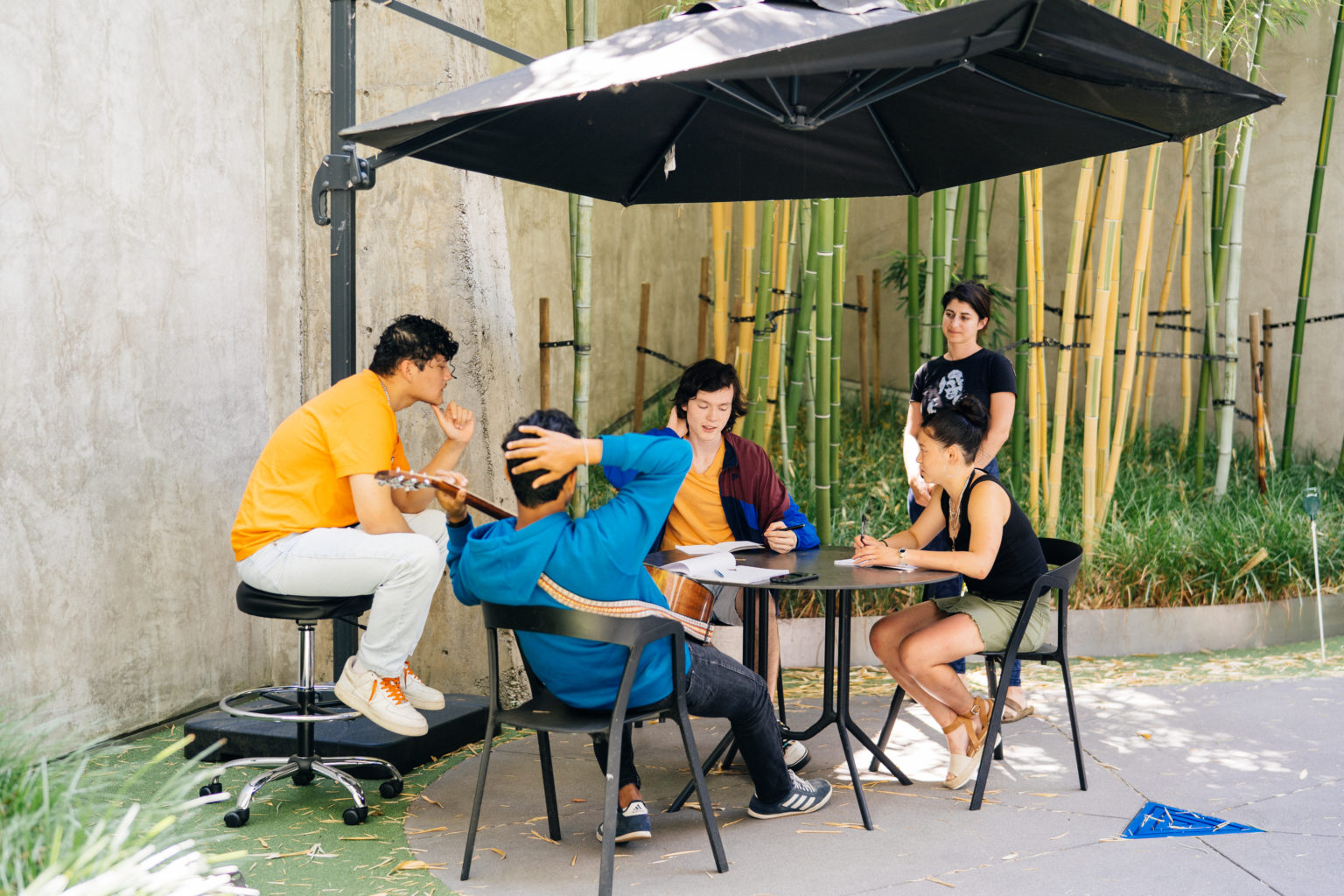 Students and instructor sitting around a table outside